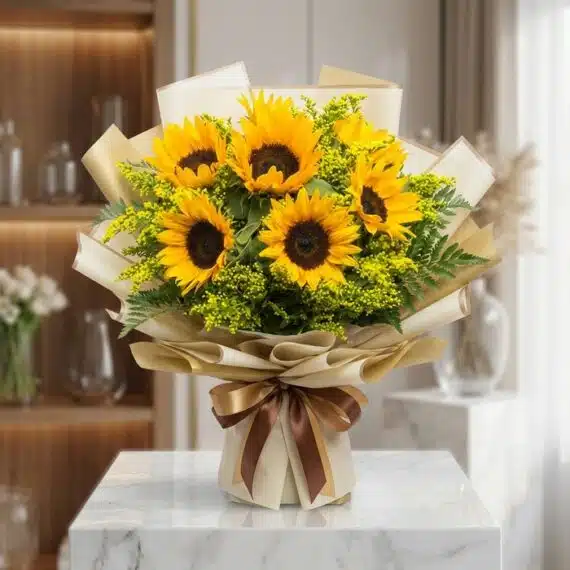 Bouquet de Girasoles LAIA: Frescura y Radiante Belleza para Regalar Bouquet de Girasoles LAIA con 10 flores frescas y radiantes, envuelto en papel coreano elegante y lazo marrón, sobre mármol b
