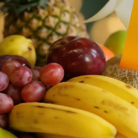 Primer plano extremo de la Canasta de Frutas Sirio con textura hiperrealista, gotas de rocío sutiles y colores vibrantes, des
